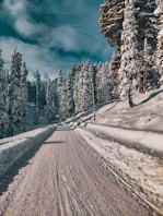 a person riding a snowboard down a snow covered road