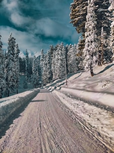 a person riding a snowboard down a snow covered road