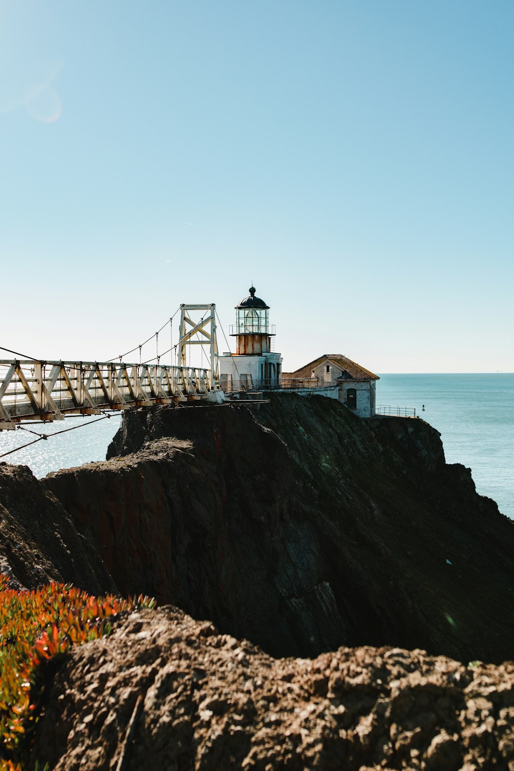 a light house sitting on top of a cliff next to the ocean