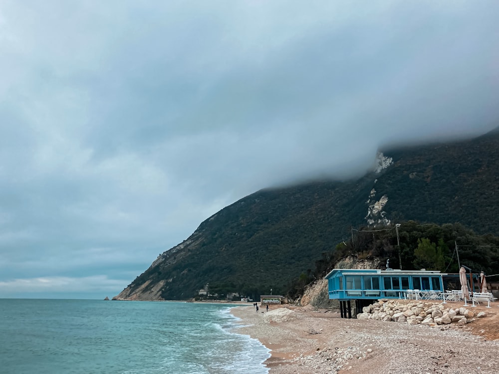 a blue bus parked on the side of a beach