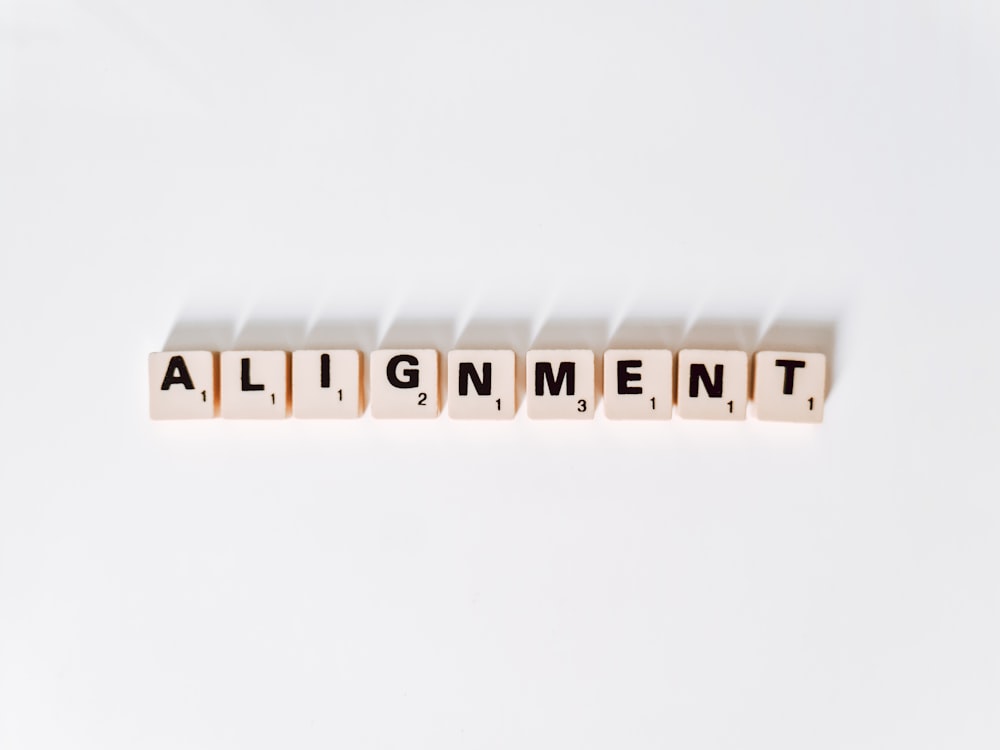 the word alignmentment spelled with scrabble letters