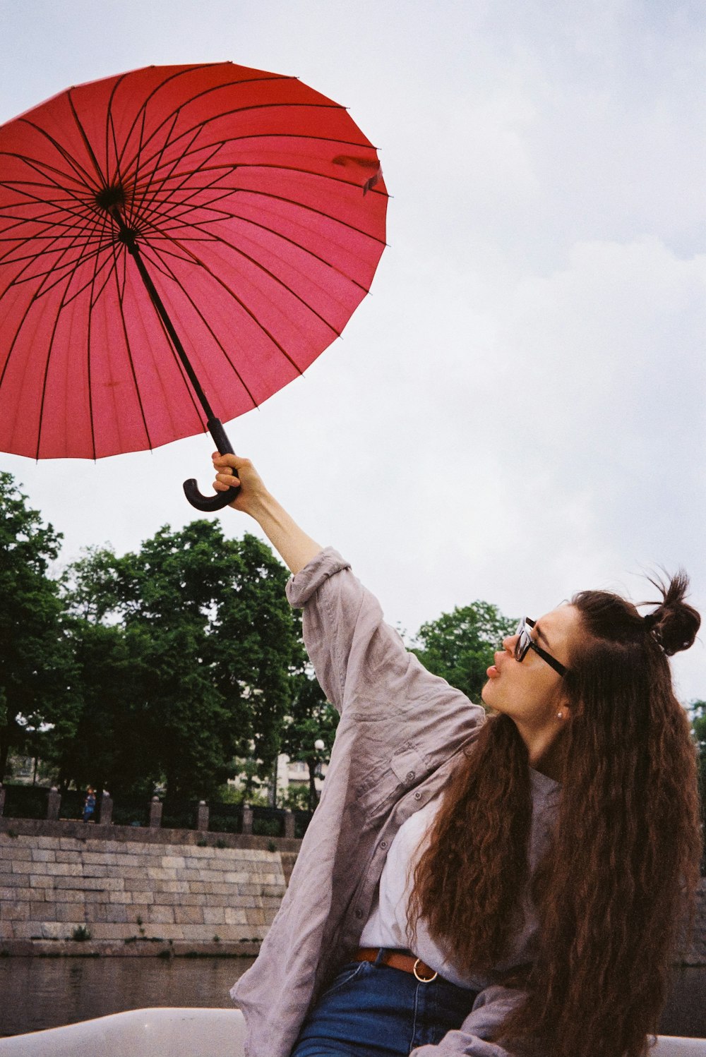a woman holding a red umbrella over her head