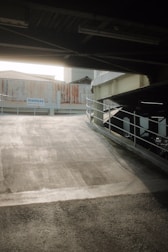a person riding a skateboard under a bridge