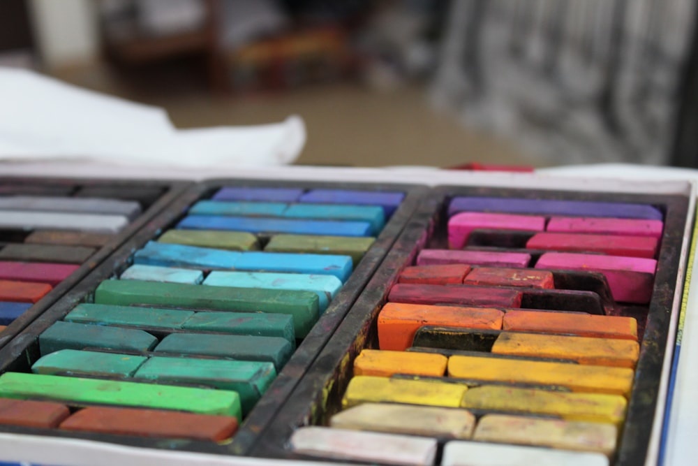 a tray of colored crayons sitting on a table