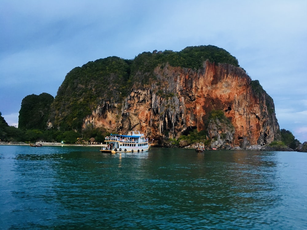 a boat floating on a body of water near a mountain