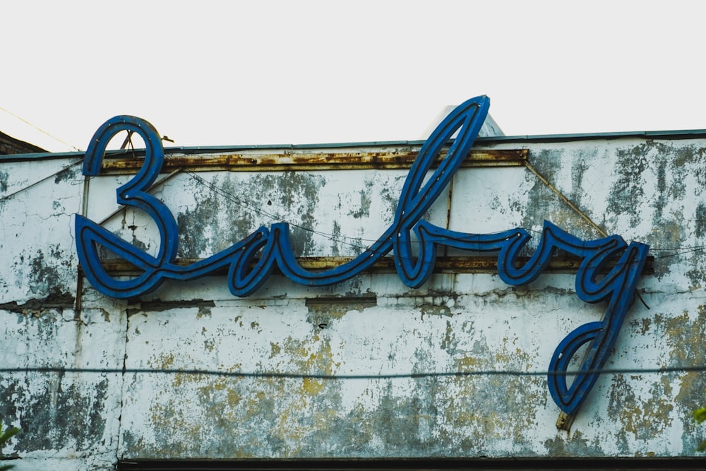 a blue neon sign on the side of a building