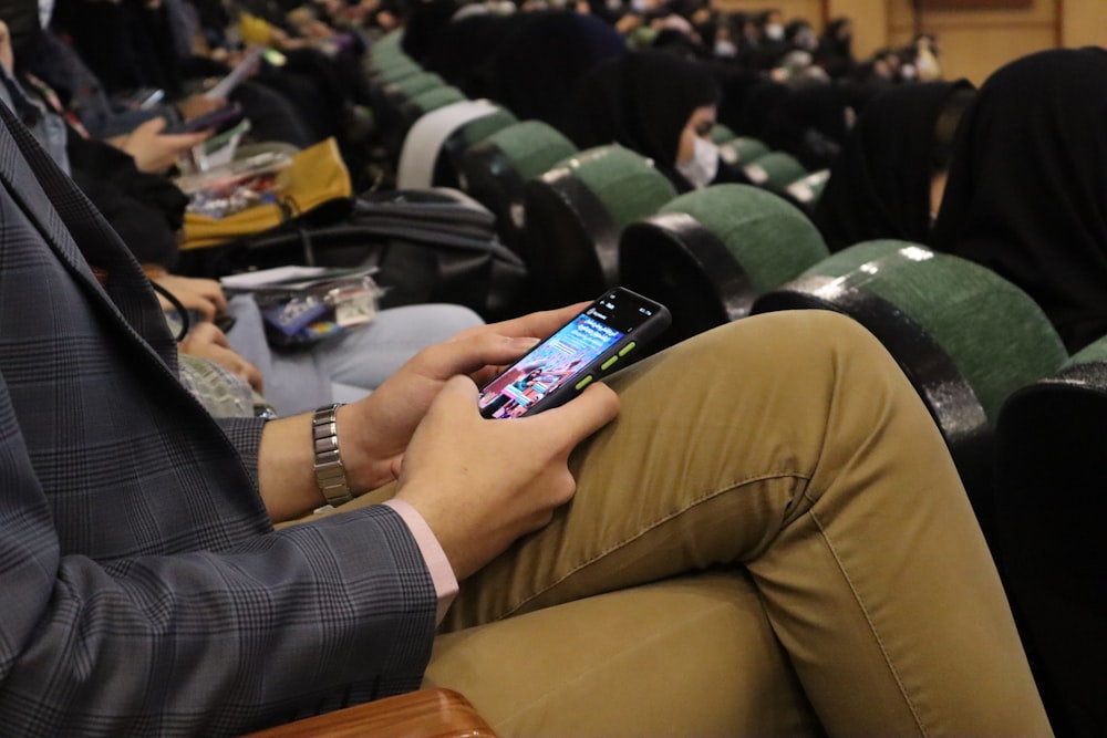 a person sitting in a chair using a cell phone