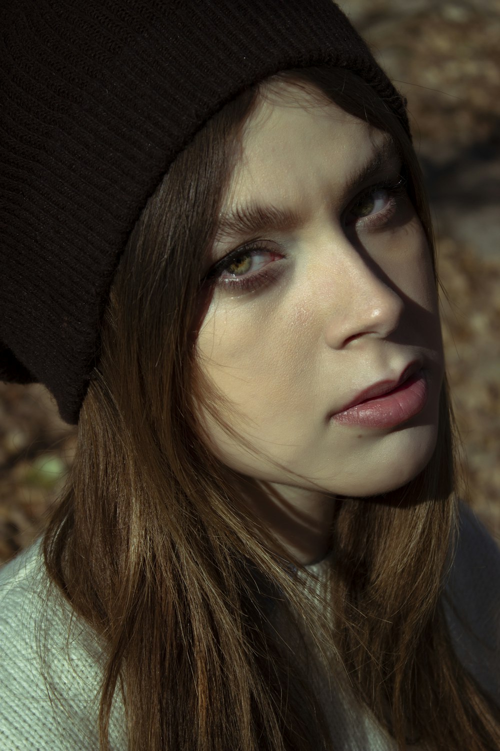 a woman with long hair wearing a beanie