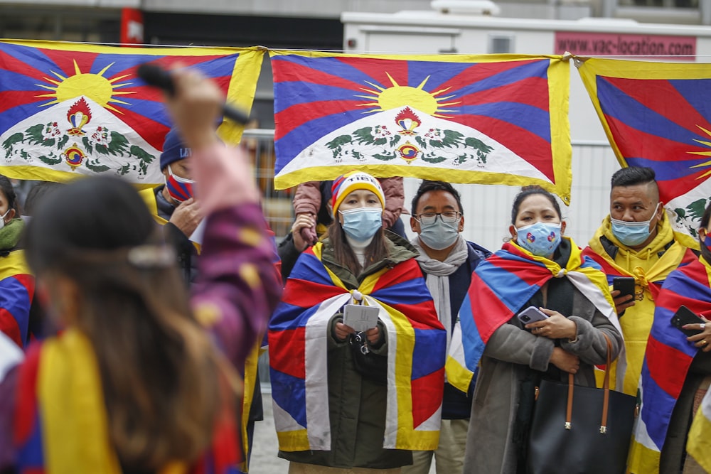 a group of people wearing masks and holding flags