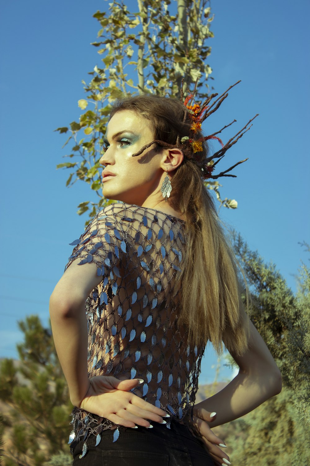 a woman with makeup on her face and a tree in the background