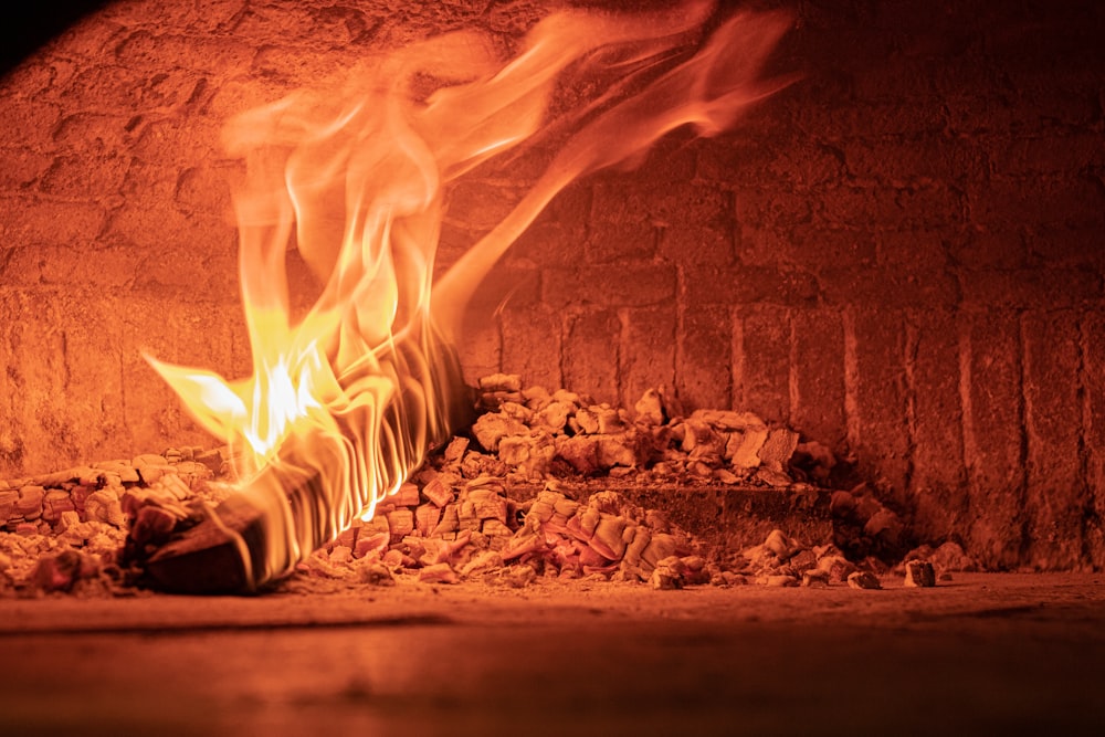 a fire burning inside of a brick oven
