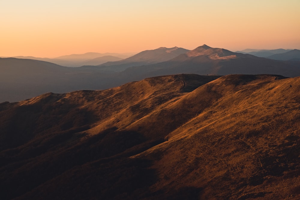 uma vista de uma cordilheira ao pôr do sol