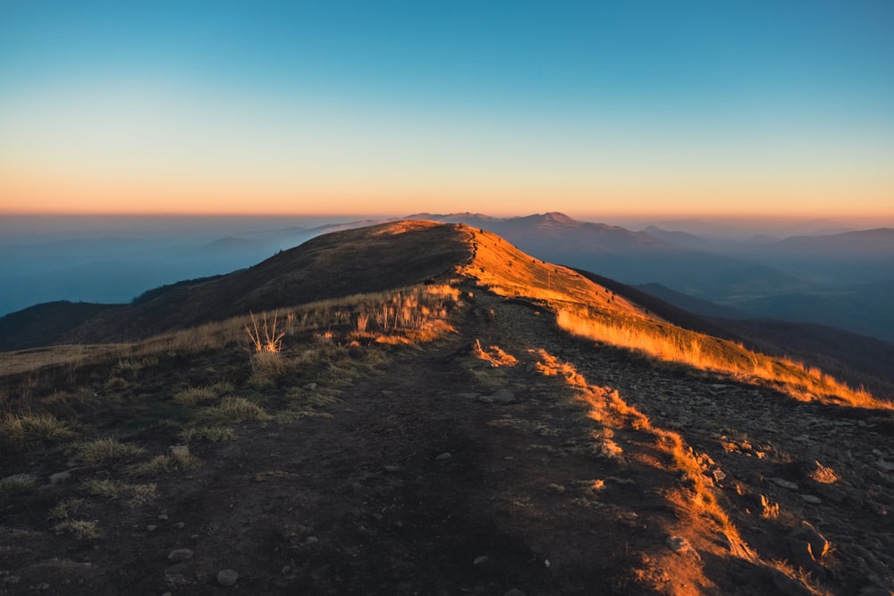 the sun is setting on the top of a mountain