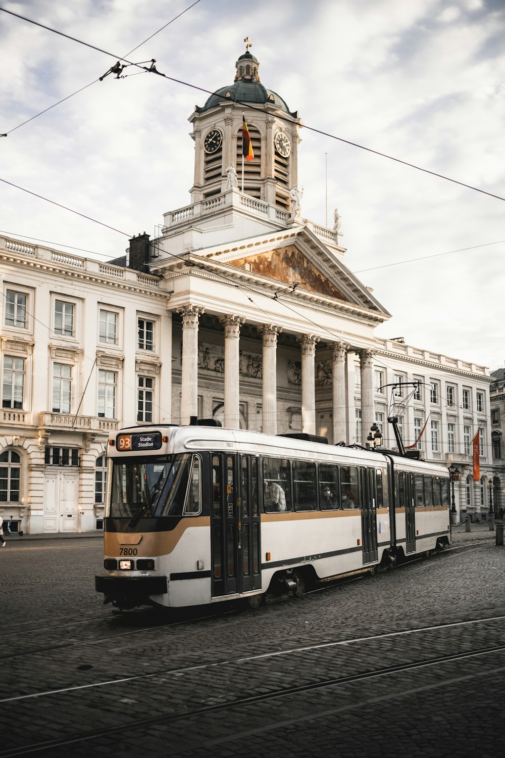 a bus driving down a street next to a tall building