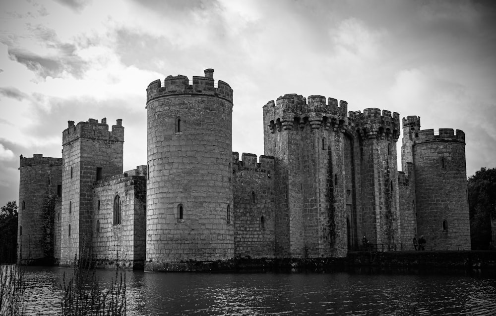 a black and white photo of a castle by the water