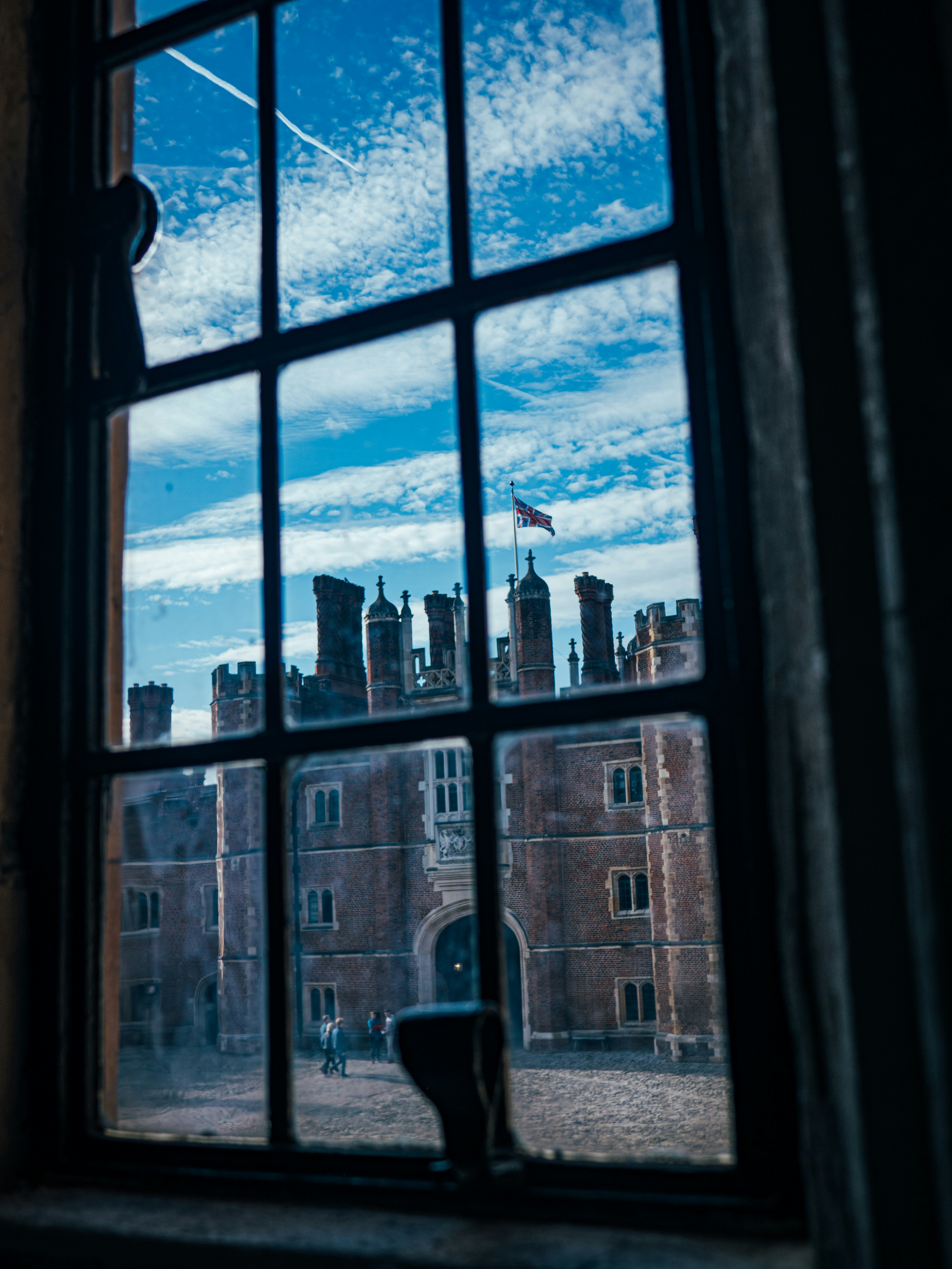 Looking out a window at the Union Jack at Hampton Court Palace.