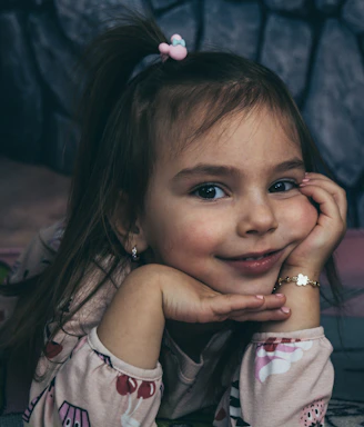 a little girl laying on top of a bed