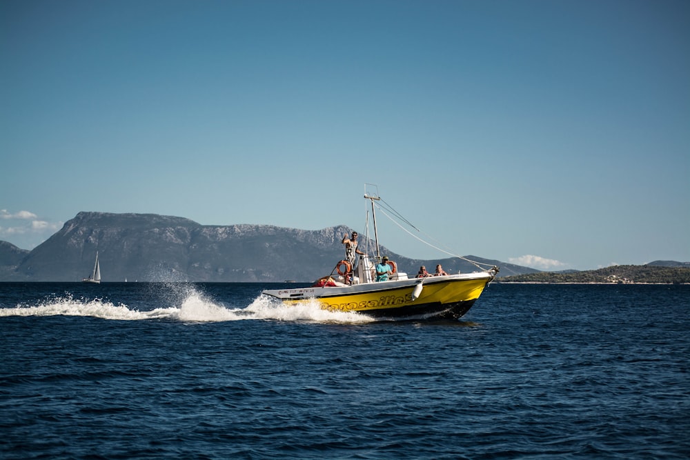 a yellow boat with people on it in the water