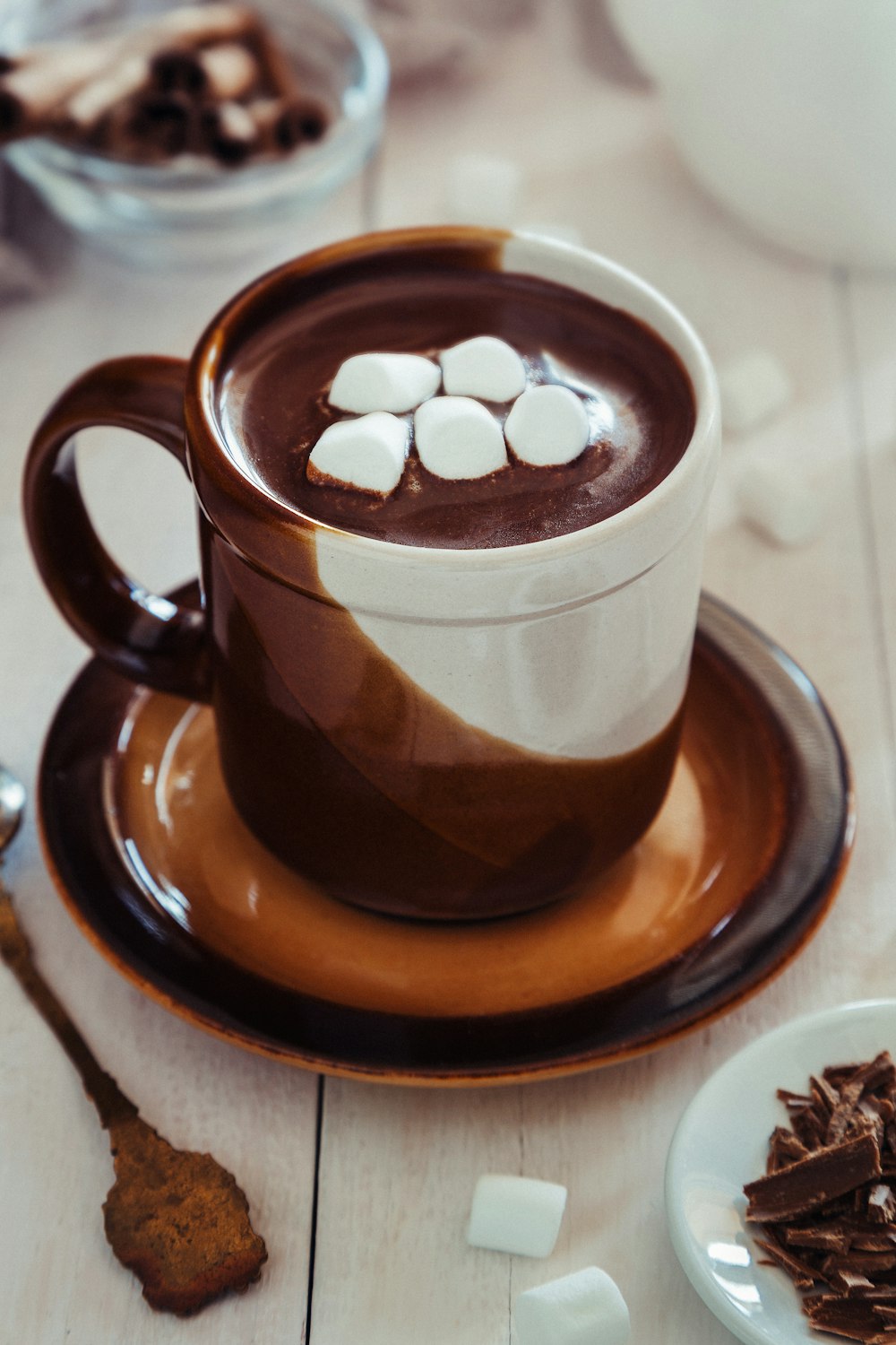 a cup of hot chocolate with marshmallows on a saucer