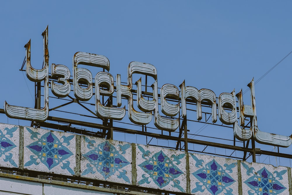 a sign on top of a building with a sky background