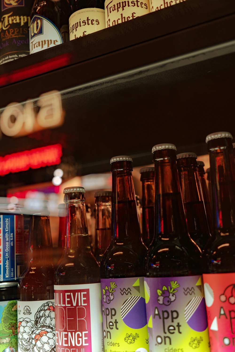 Una fila de botellas de cerveza encima de un estante