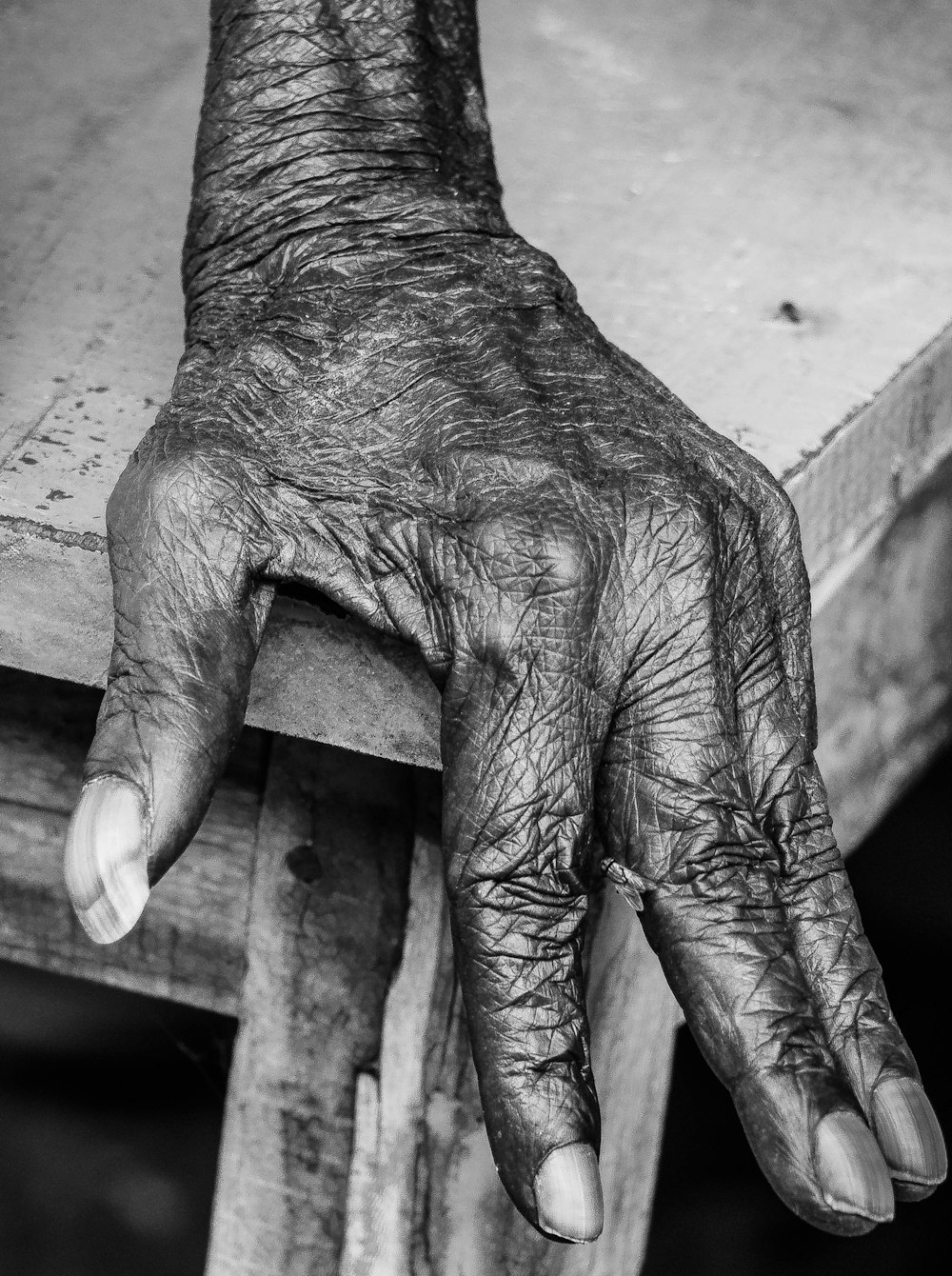 a black and white photo of a person's hand on a table