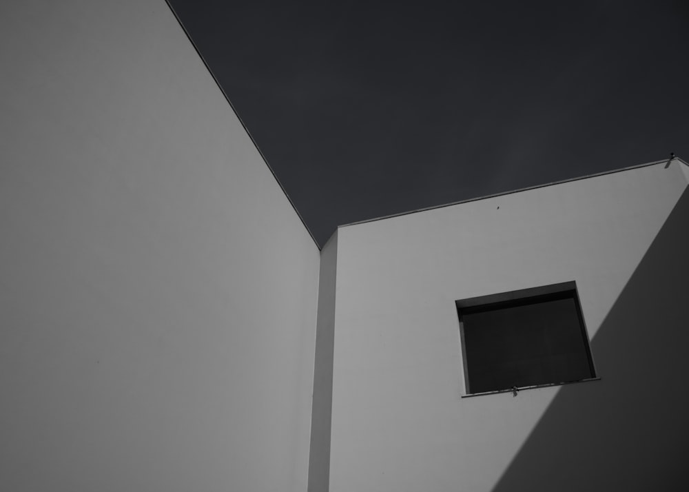 une fenêtre carrée dans un coin de mur