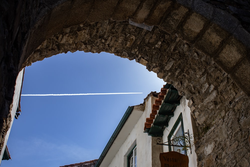 an airplane is flying in the sky over a building