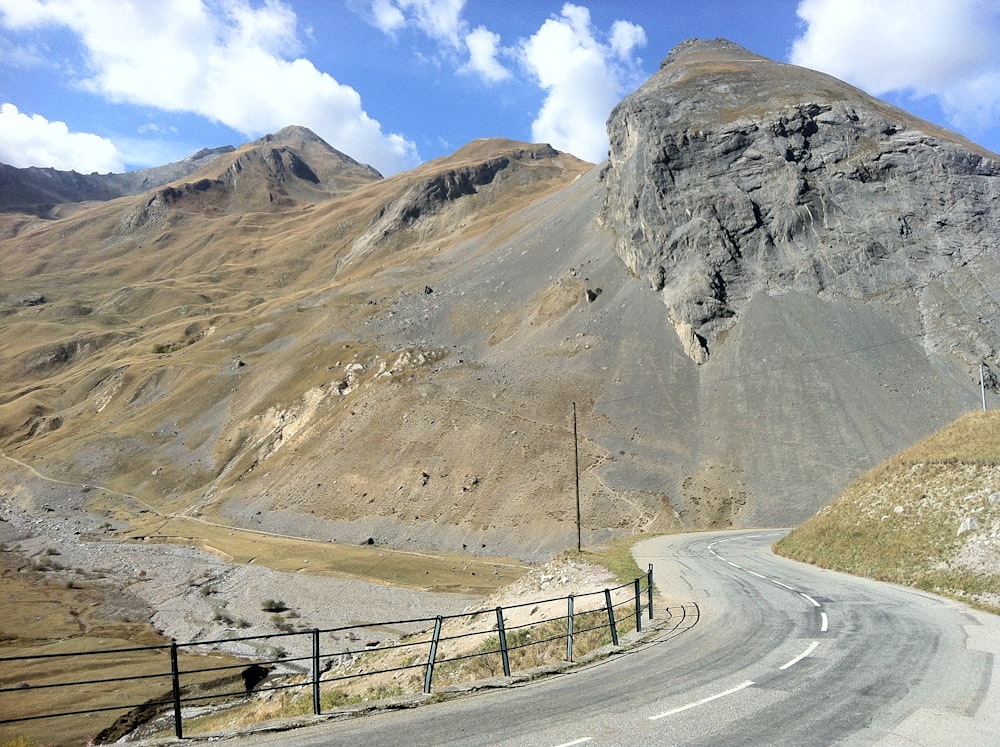 a winding road with a mountain in the background