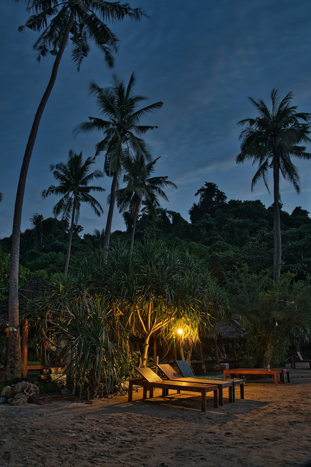 a couple of benches sitting on top of a sandy beach