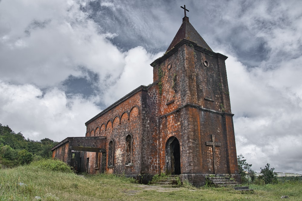 an old church with a steeple on a cloudy day