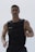 A muscular man is seen wearing a weighted vest, possibly for exercise or training. He has short hair and facial stubble, and appears focused and determined.