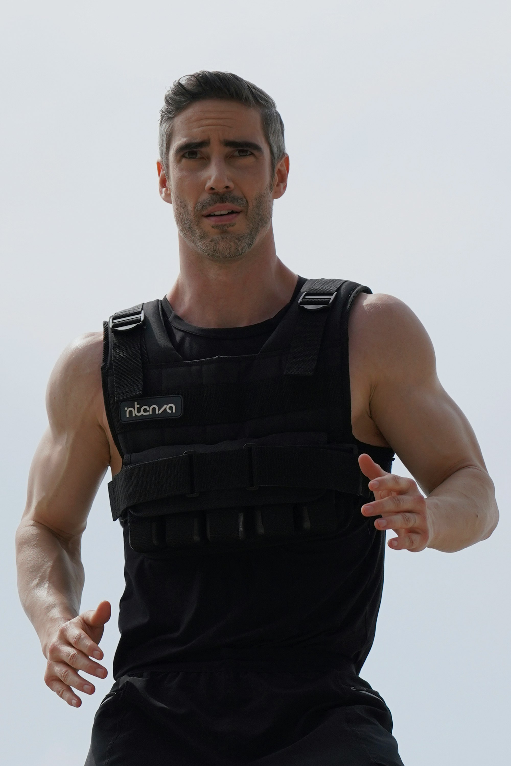 Athletic handsome, mature male wearing a 25lbs Intenza Weight Vest whilst exercising outdoors.