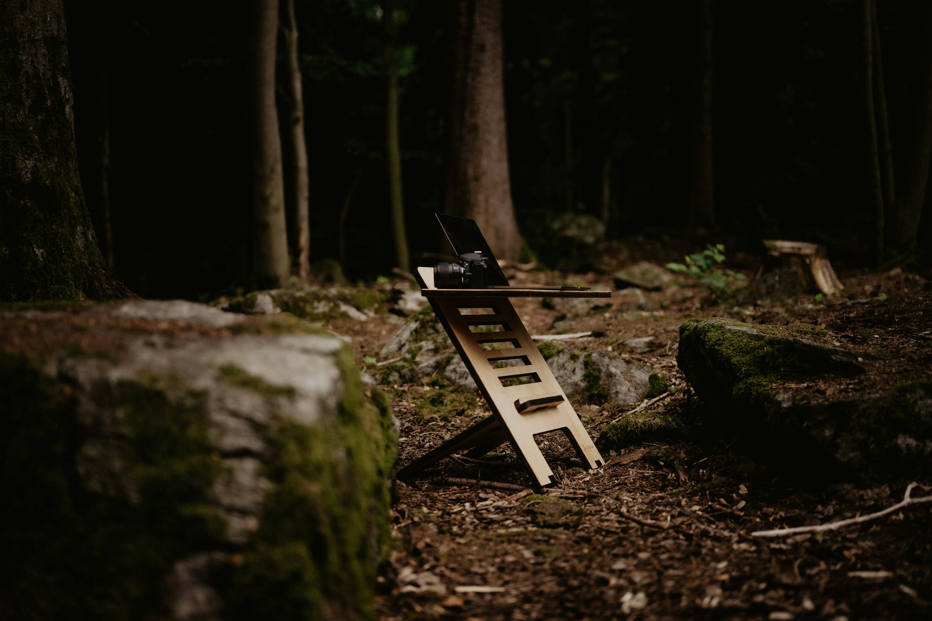 a wooden bench sitting in the middle of a forest