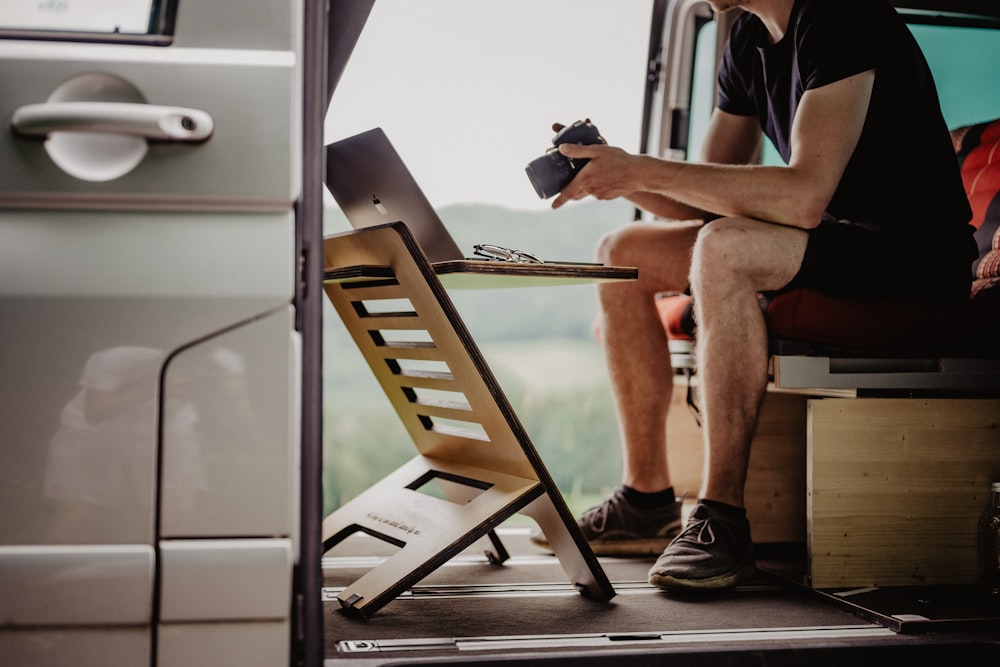 Un homme assis à l’arrière d’une camionnette