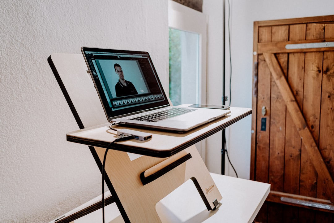 a laptop computer sitting on top of a wooden desk,