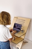 a child using a laptop computer on a stand