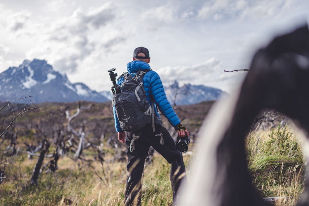 a man with a backpack walking through a field