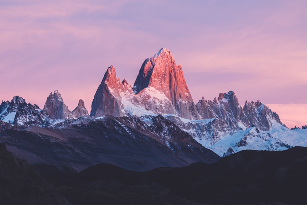 a mountain range with a pink sky in the background