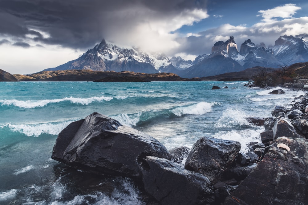 a rocky beach with a mountain range in the background