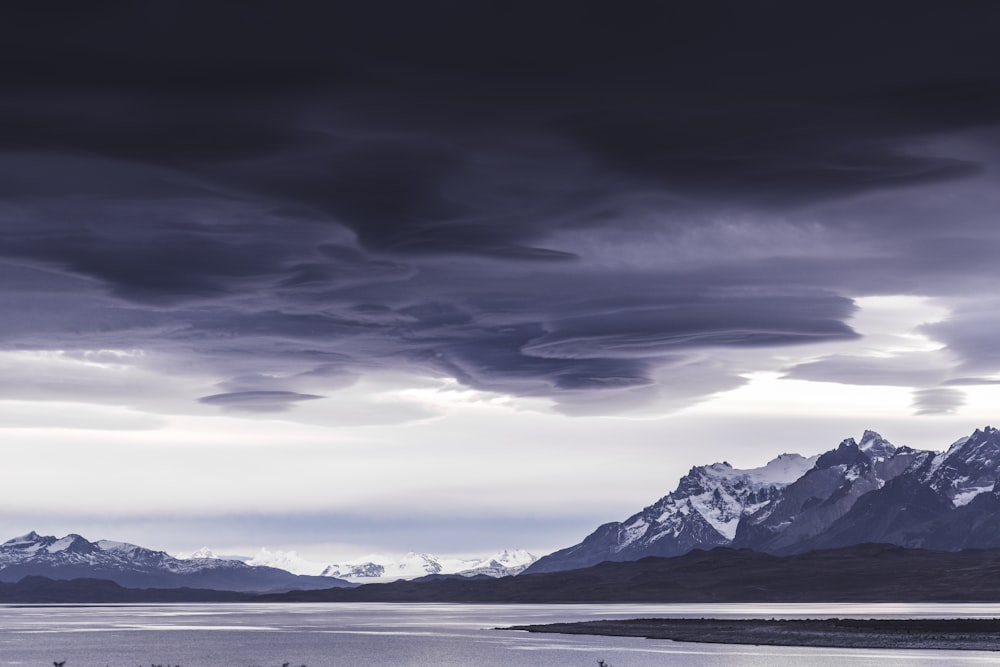 a large body of water with mountains in the background