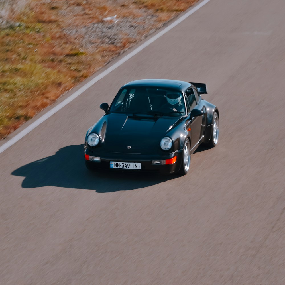 a black sports car driving down a road