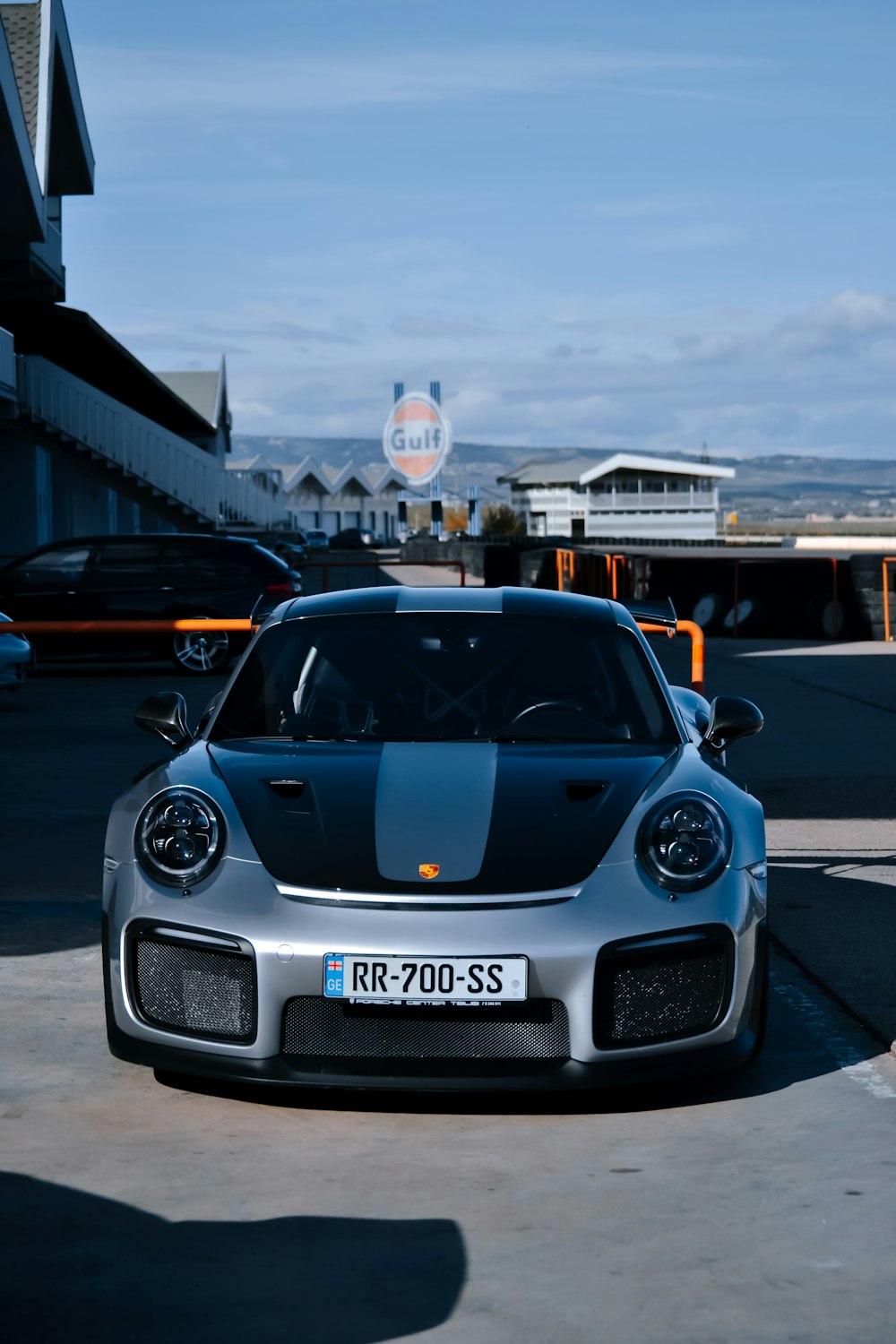 a silver and black sports car parked in a parking lot