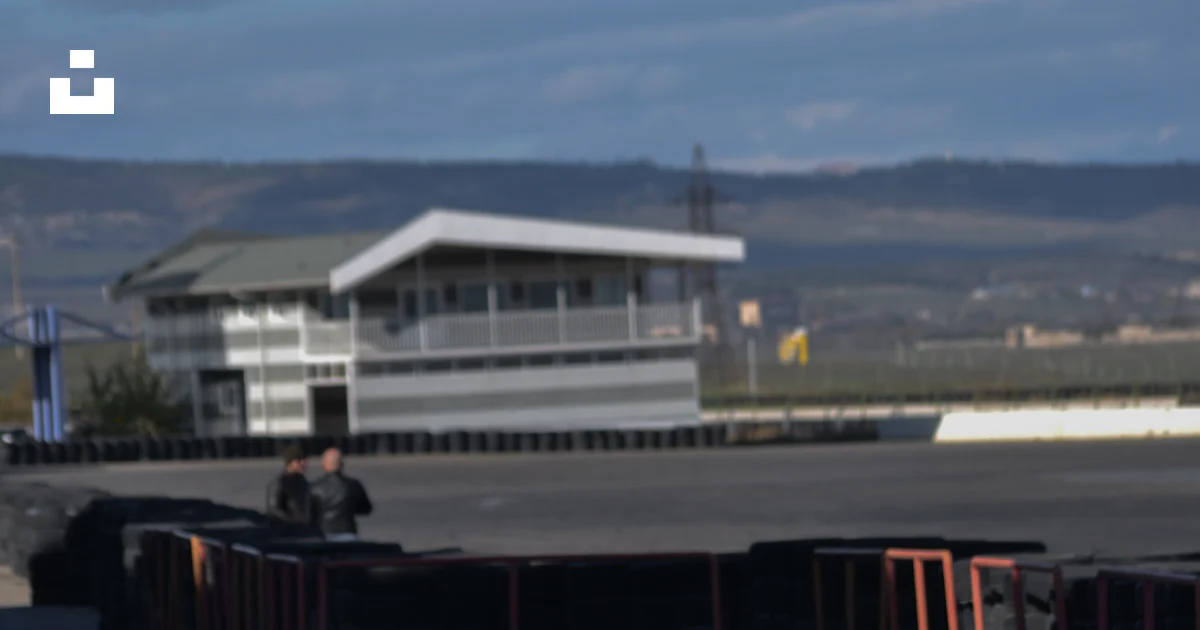 A blue car driving down a race track photo – Free Rustavi international ...