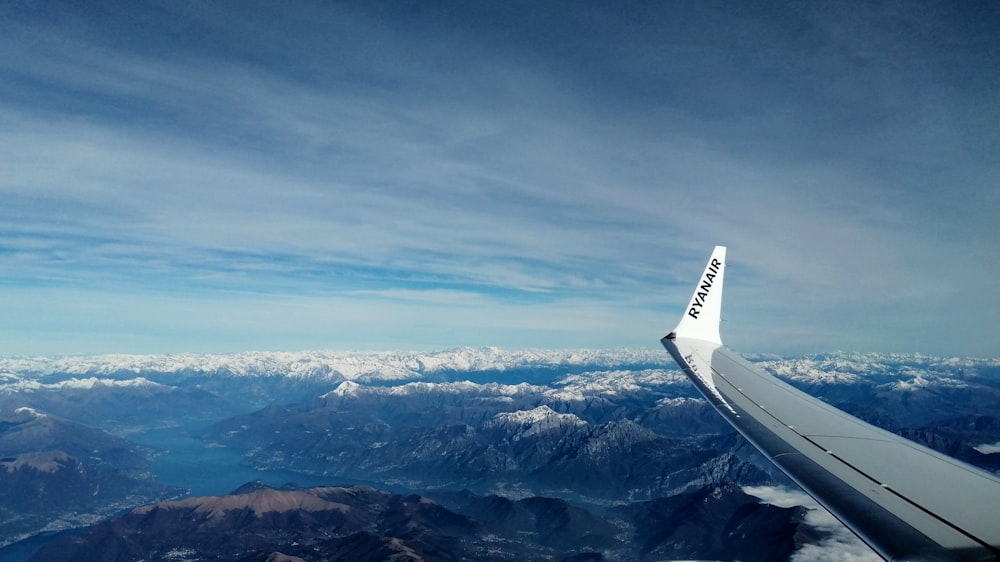 an airplane wing flying over a mountain range