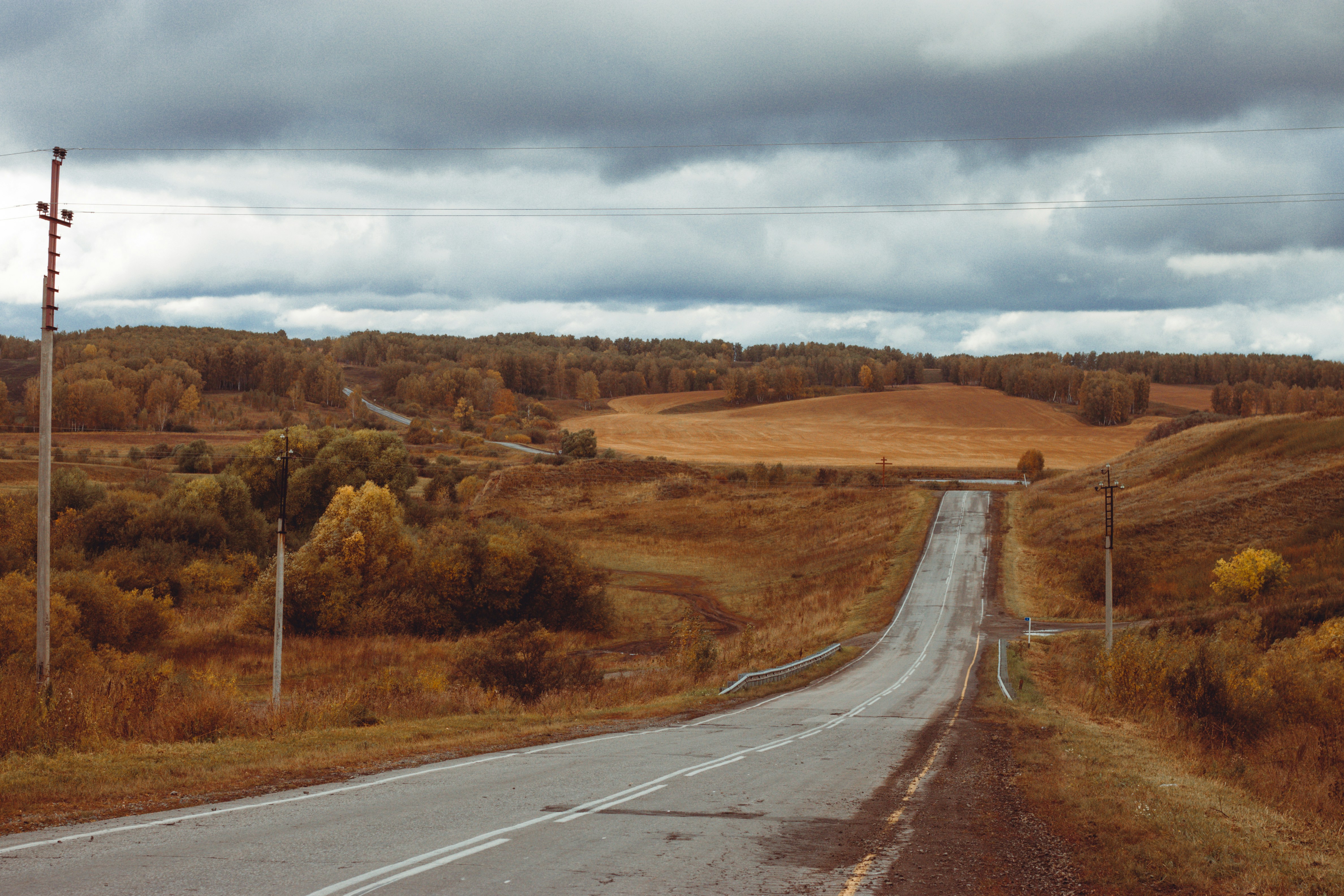 an empty road in the middle of a field