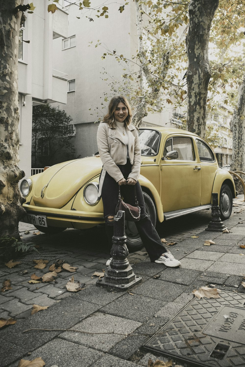 a woman sitting on the hood of a yellow car