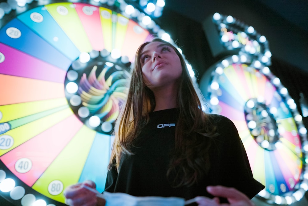 a woman standing in front of a wheel of fortune