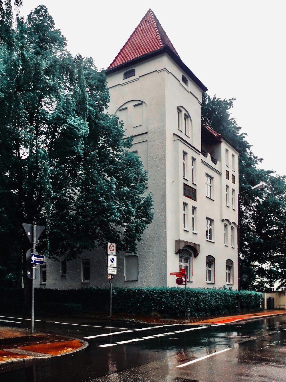 a tall white building with a red roof