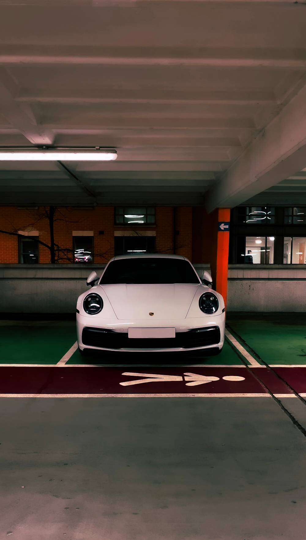 a white sports car parked in a parking garage